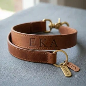 A personalized leather keychain strap featuring custom engraved initials on the leather surface.